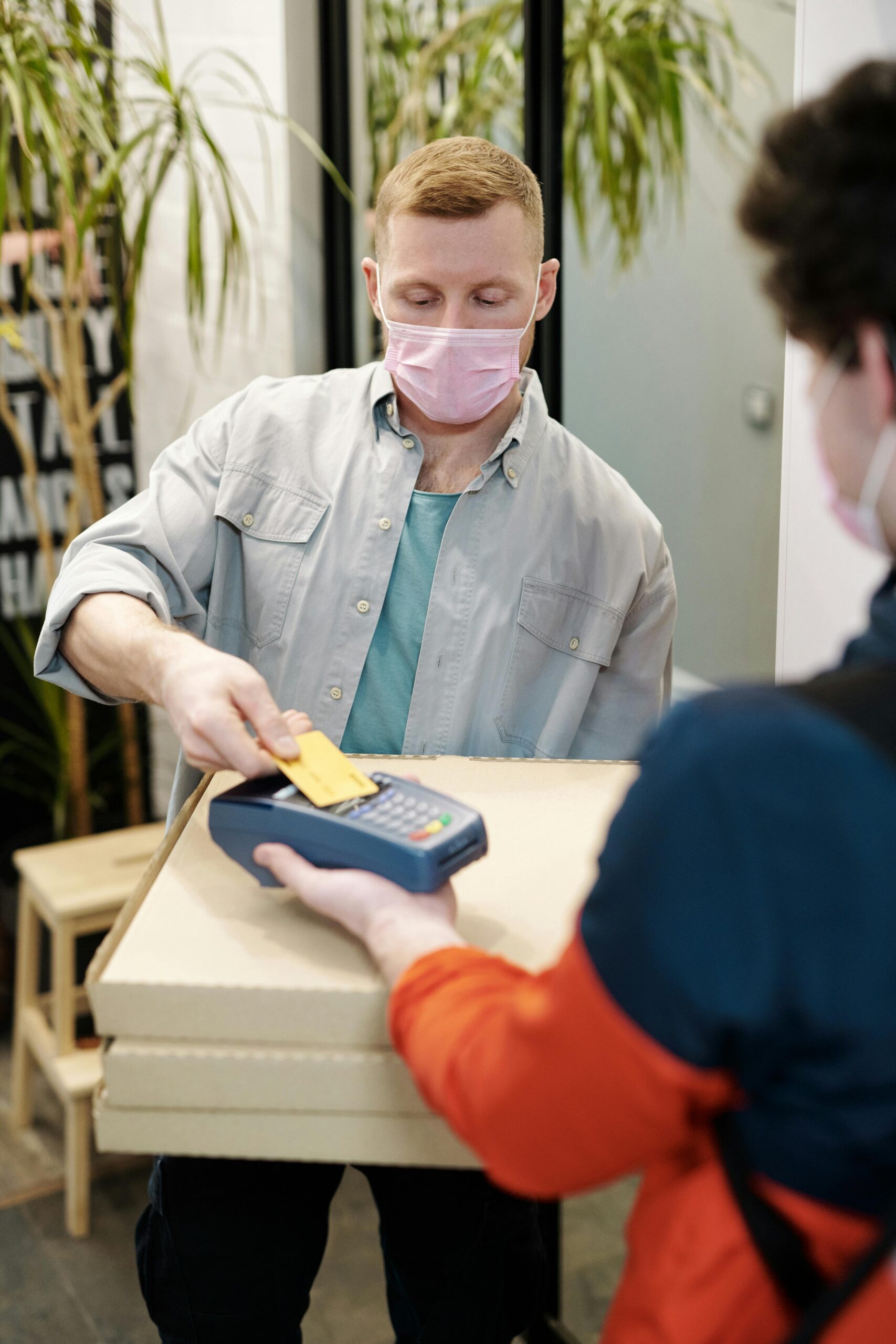 Masked delivery interaction with contactless payment for safety.